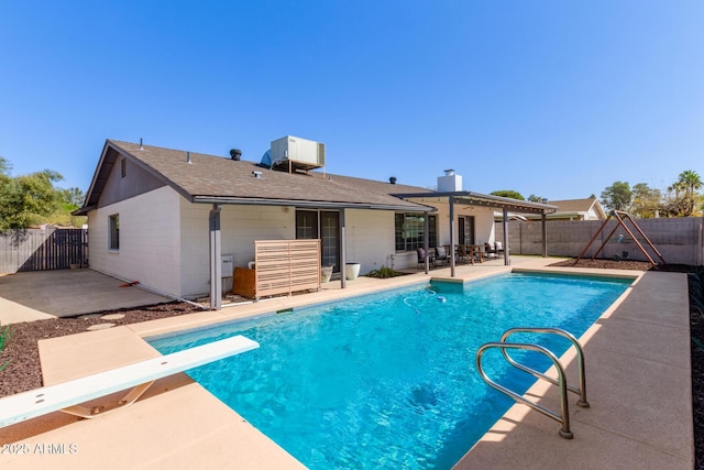 view of pool with a patio, a diving board, a fenced backyard, and a fenced in pool