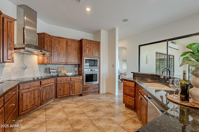 28423 N 139th St, Scottsdale, AZ 85262 - kitchen featuring brown cabinets, stainless steel appliances, arched walkways, a sink, and wall chimney range hood