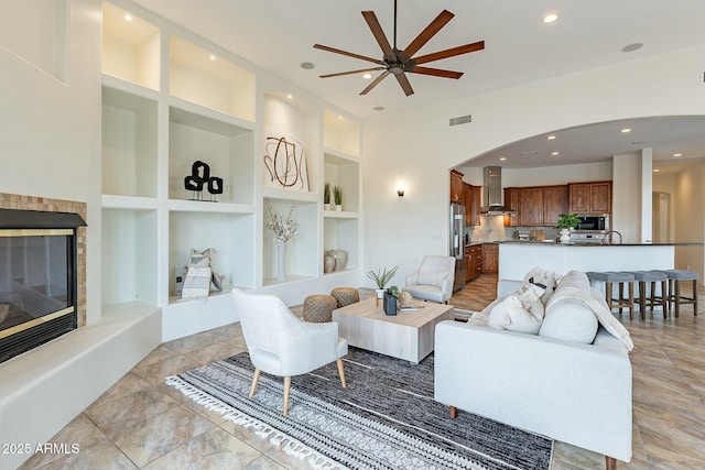 28423 N 139th St, Scottsdale, AZ 85262 - living room featuring built in shelves, a glass covered fireplace, visible vents, ceiling fan, and recessed lighting