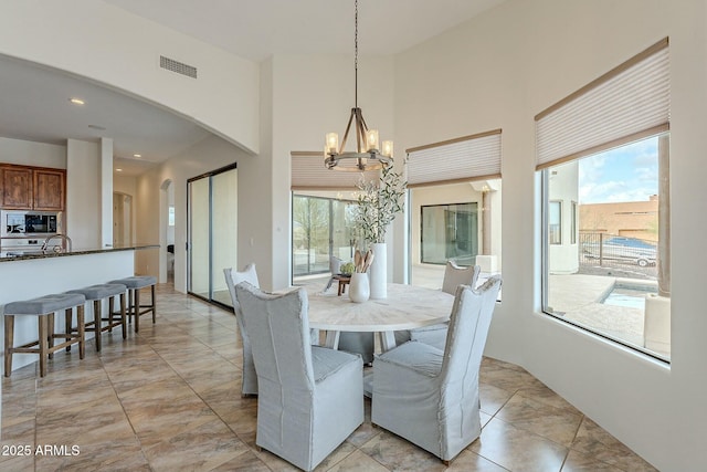 28423 N 139th St, Scottsdale, AZ 85262 - dining room featuring arched walkways, a healthy amount of sunlight, a chandelier, and visible vents