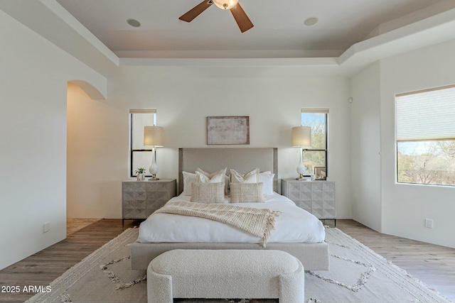 28423 N 139th St, Scottsdale, AZ 85262 - bedroom with arched walkways, a tray ceiling, wood finished floors, and ceiling fan