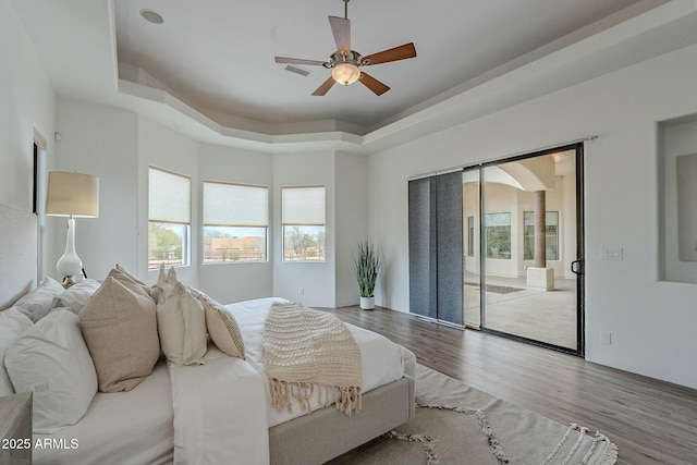 28423 N 139th St, Scottsdale, AZ 85262 - bedroom with visible vents, a tray ceiling, ceiling fan, and wood finished floors
