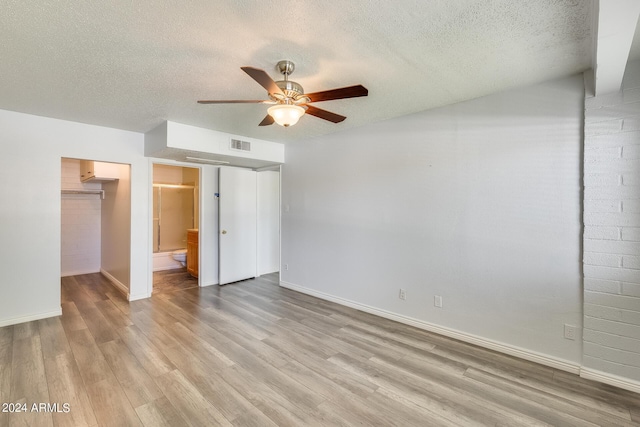 unfurnished bedroom featuring baseboards, visible vents, light wood-style flooring, a textured ceiling, and a closet