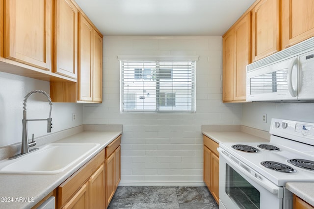 kitchen featuring white appliances, light brown cabinets, light countertops, and a sink