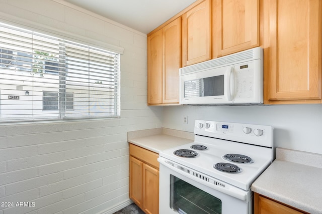 kitchen with light countertops, white appliances, and light brown cabinets