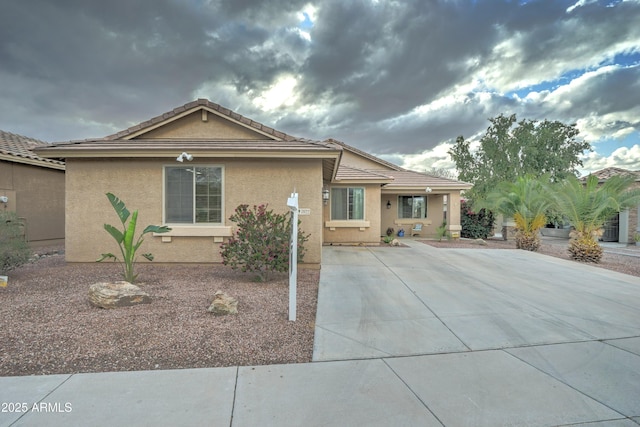 ranch-style house featuring a tiled roof and stucco siding