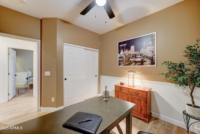 office area with a ceiling fan, baseboards, and light wood finished floors