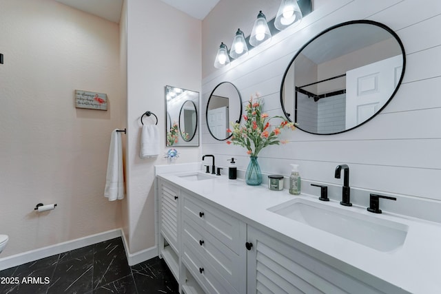 full bathroom featuring marble finish floor, toilet, baseboards, and a sink