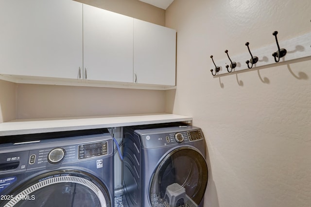 washroom with cabinet space and washing machine and clothes dryer