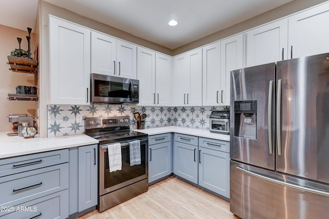 kitchen featuring backsplash, appliances with stainless steel finishes, and light countertops