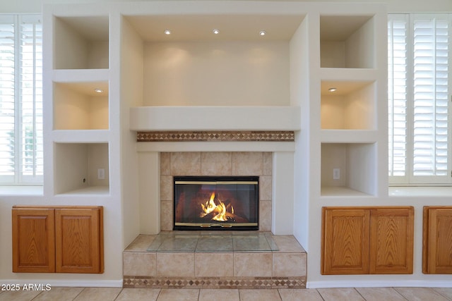 details featuring a tile fireplace and built in features