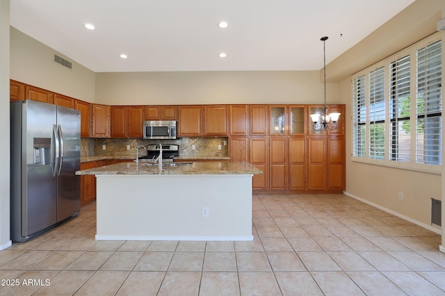 kitchen featuring an inviting chandelier, light tile patterned floors, pendant lighting, stainless steel appliances, and backsplash