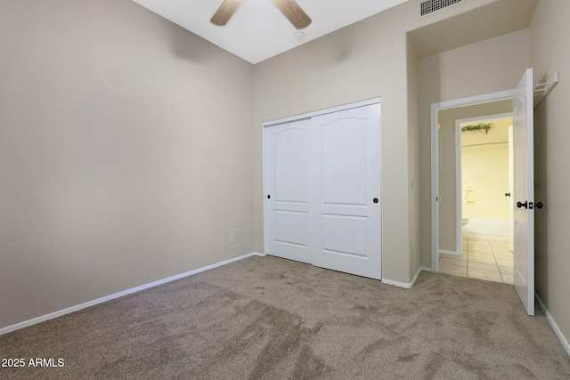 unfurnished bedroom featuring ceiling fan, light colored carpet, and a closet