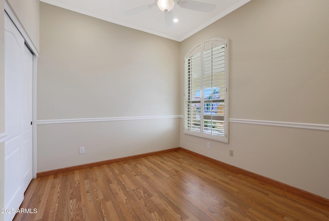 empty room with ceiling fan, ornamental molding, and light wood-type flooring