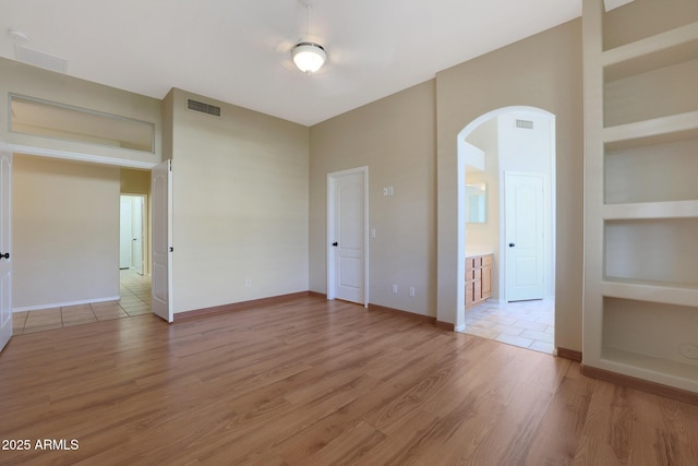 unfurnished room with hardwood / wood-style floors and built in features