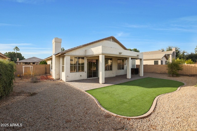 rear view of house with a patio and a yard