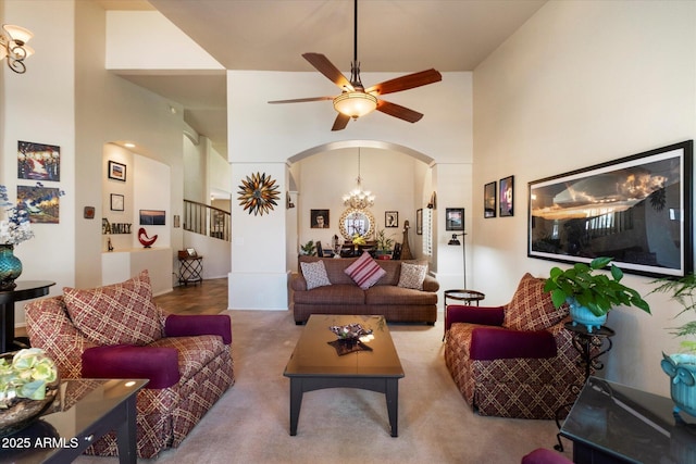 1922 E Everett Dr, Phoenix, AZ 85022 - living room featuring arched walkways, a towering ceiling, ceiling fan, carpet, and a chandelier