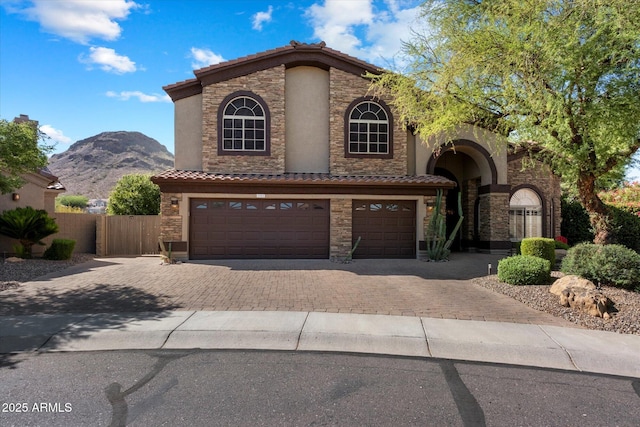 1922 E Everett Dr, Phoenix, AZ 85022 - mediterranean / spanish home featuring a garage, decorative driveway, and stone siding