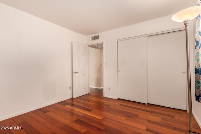 unfurnished bedroom featuring wood-type flooring and a closet