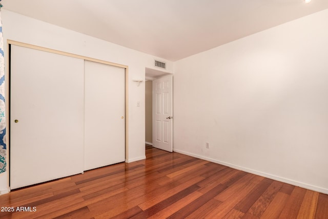 unfurnished bedroom with wood-type flooring and a closet