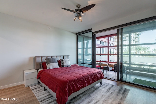 bedroom featuring floor to ceiling windows, wood-type flooring, and ceiling fan