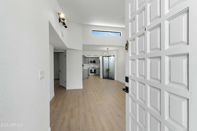 interior space with a high ceiling and light wood-type flooring