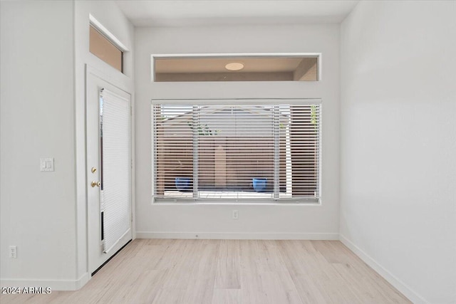 foyer with light wood finished floors and baseboards