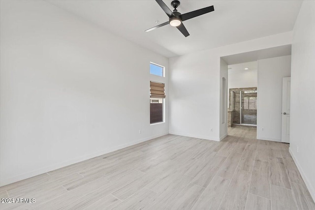 empty room with a ceiling fan, light wood-type flooring, and baseboards