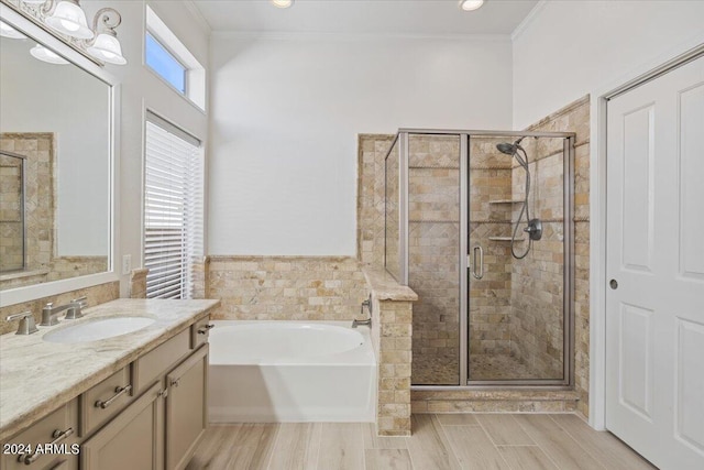 bathroom with ornamental molding, a stall shower, wood tiled floor, vanity, and a bath