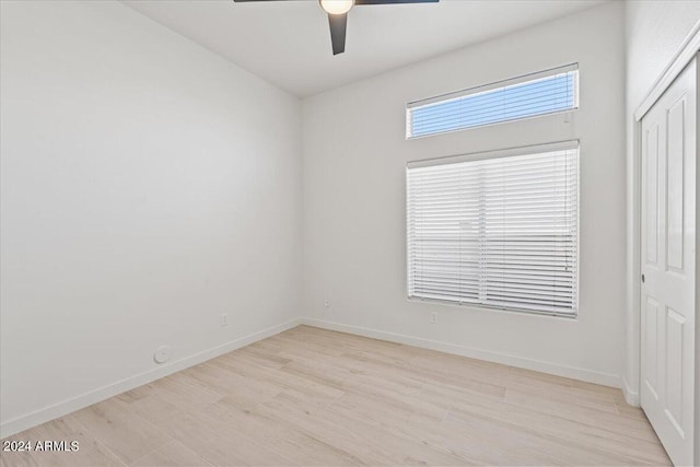 empty room with light wood-type flooring, ceiling fan, and baseboards