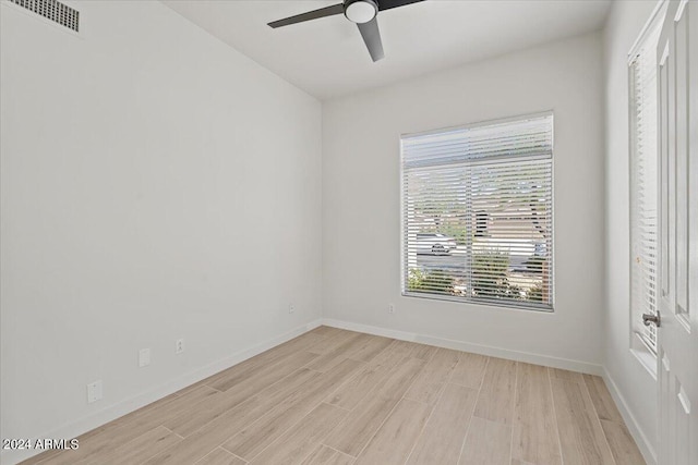 empty room featuring ceiling fan, light wood-type flooring, visible vents, and baseboards