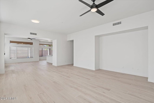 unfurnished room featuring ceiling fan, light wood-style flooring, visible vents, and baseboards