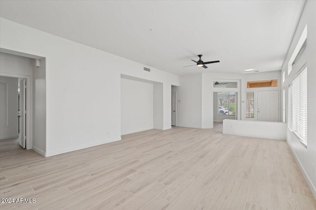 unfurnished living room with baseboards, a ceiling fan, visible vents, and light wood-style floors