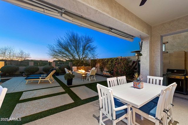 view of patio / terrace featuring an outdoor fire pit, outdoor dining area, area for grilling, and fence