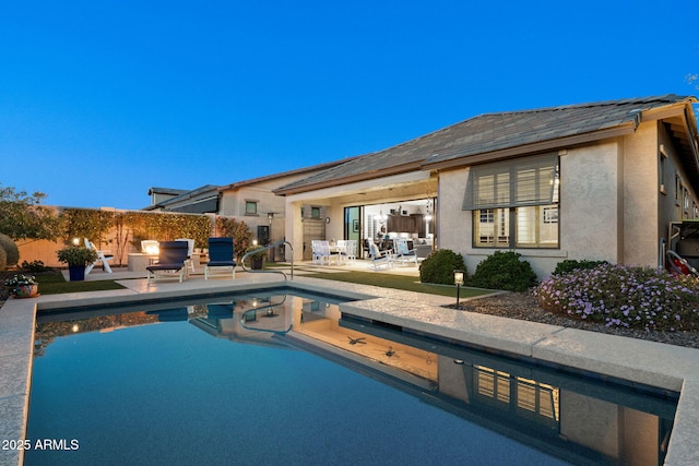 back of property featuring a fenced in pool, stucco siding, area for grilling, a patio area, and fence