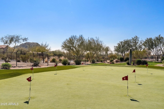 view of home's community featuring view of golf course and fence