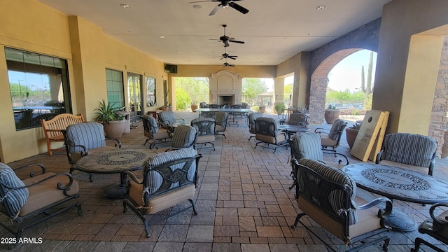 view of patio / terrace with exterior fireplace and a ceiling fan