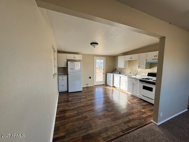 kitchen with sink, dark hardwood / wood-style flooring, washer / clothes dryer, white appliances, and white cabinets