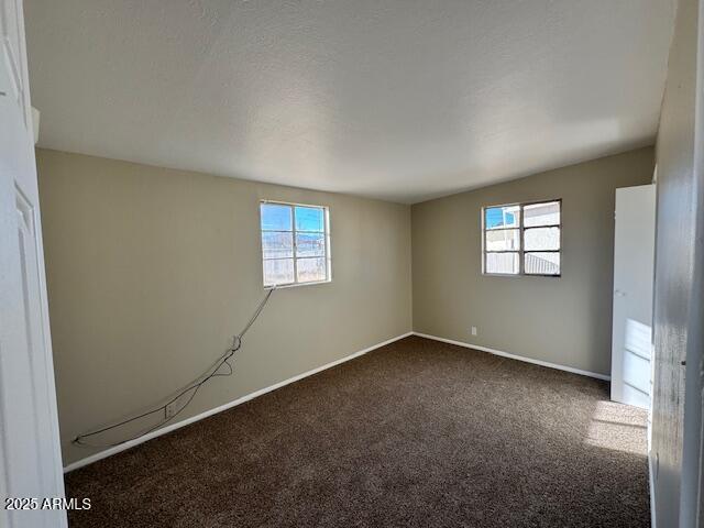 empty room featuring dark colored carpet