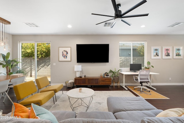 living room with a wealth of natural light, visible vents, and wood finished floors