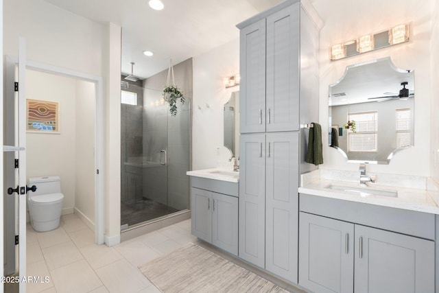 bathroom featuring double vanity, a sink, toilet, and a shower stall