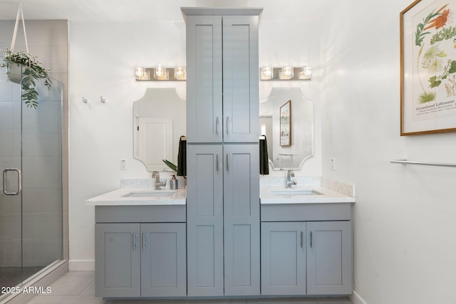 bathroom with tile patterned flooring, a sink, a shower stall, and double vanity