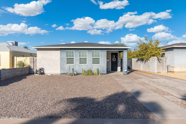 view of front facade featuring fence and stucco siding