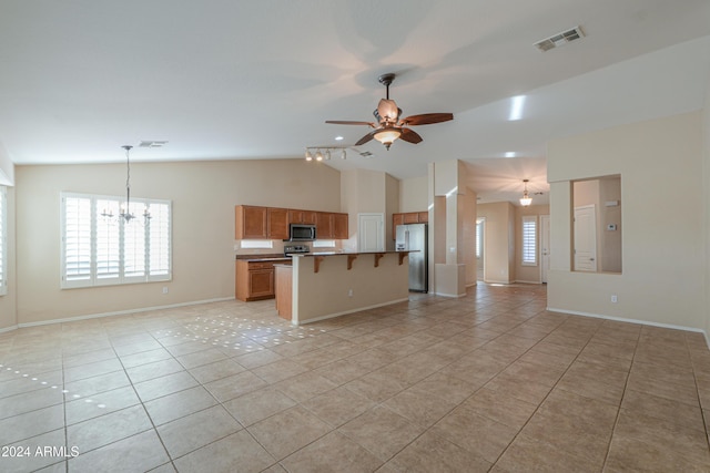 interior space with visible vents, light tile patterned flooring, vaulted ceiling, and ceiling fan with notable chandelier