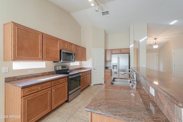 kitchen featuring brown cabinetry, visible vents, light tile patterned flooring, a sink, and stainless steel appliances