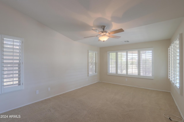 empty room with a ceiling fan and light colored carpet