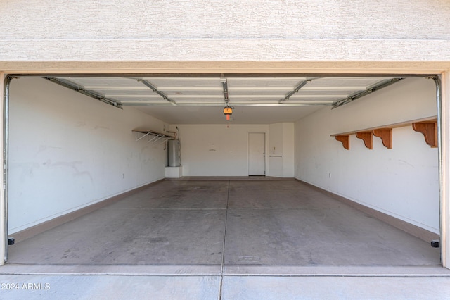 garage featuring electric water heater and baseboards