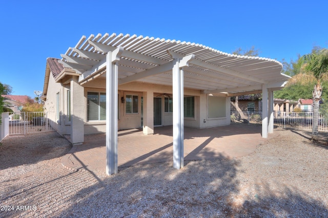 rear view of property with a patio area, a pergola, and fence