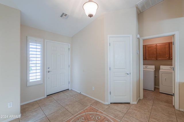 entryway with washer and clothes dryer, visible vents, baseboards, and light tile patterned floors