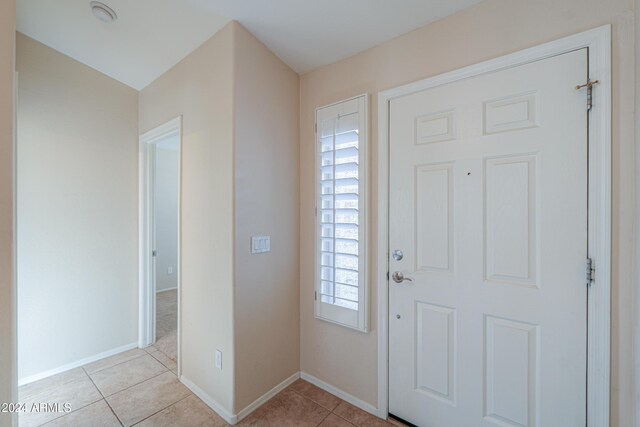 foyer entrance featuring light tile patterned floors and baseboards